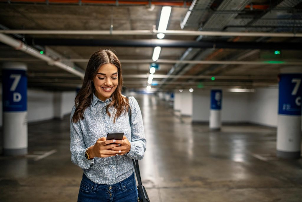 Woman using her phone in a parking garage