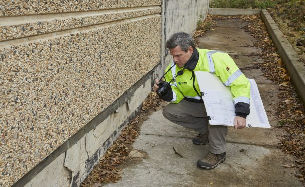 A Walker Consultants expert investigates damage to the exterior of a building