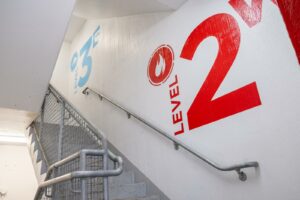 Interior staircase in a Lansing ramp with distinctive colors and icons for each floor