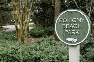 Sign for Coligny Beach Park with trees in the background