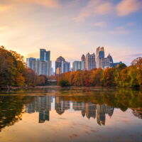 Atlanta skyline at sunset with autumn trees and a pond in the foreground