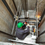 lift machinist repairing elevator in lift shaft